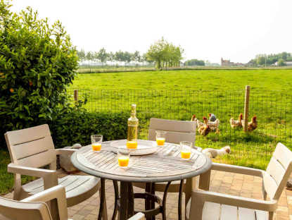 zonneterras, tuinmeubelem, groene omgeving, zicht op de weiden en polders 